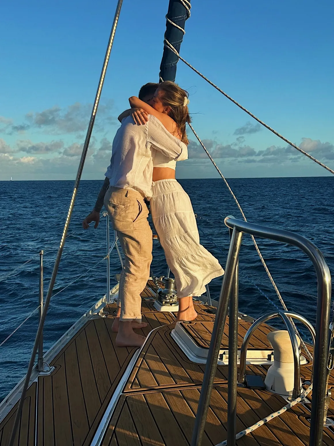 Couple hugging on the deck of Sailing Beauty after a private proposal charter in Honolulu.