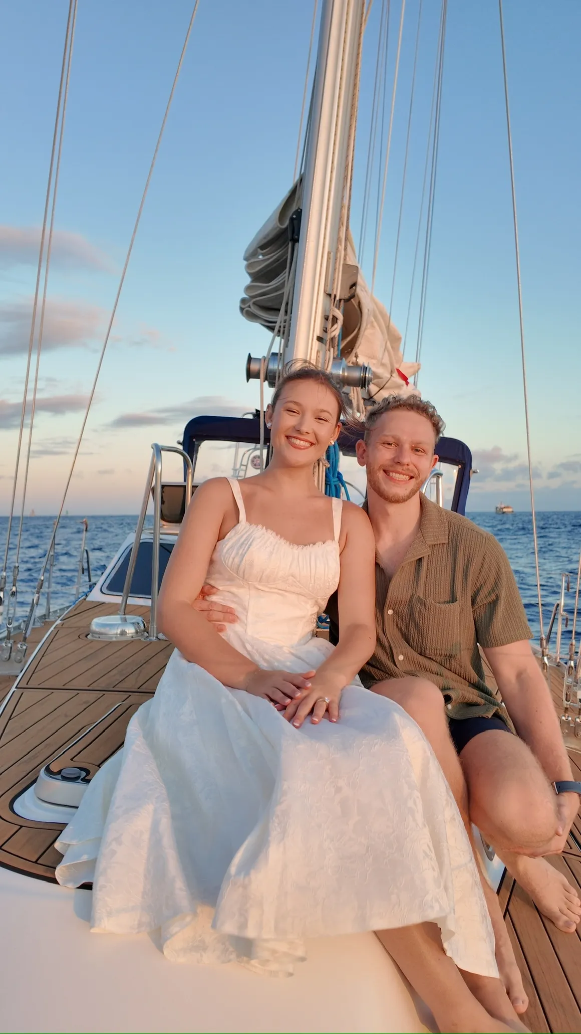 Newly married couple seated on the bow of Sailing Beauty after a Honolulu wedding charter.