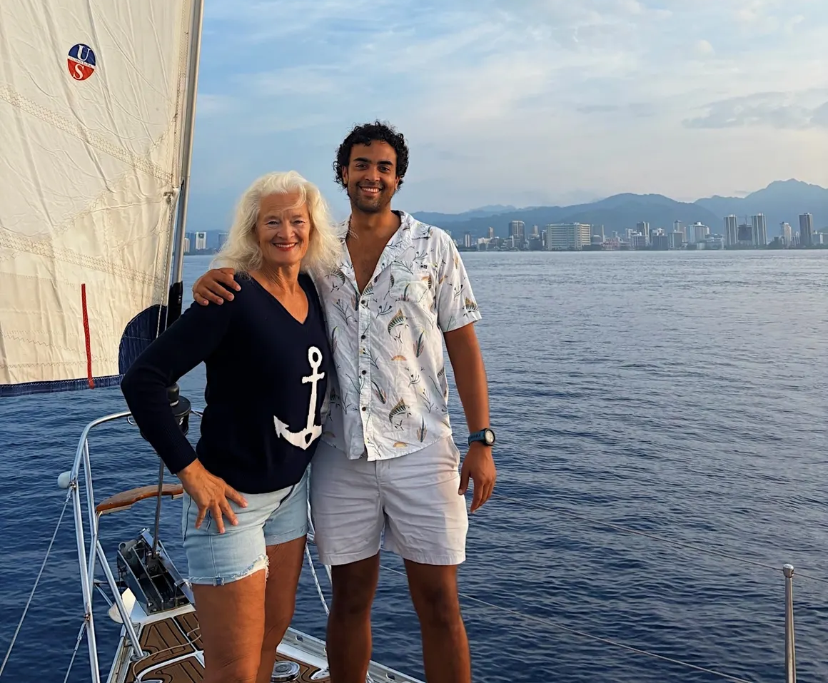 Owner and son standing on the bow of Sailing Beauty in Honolulu.