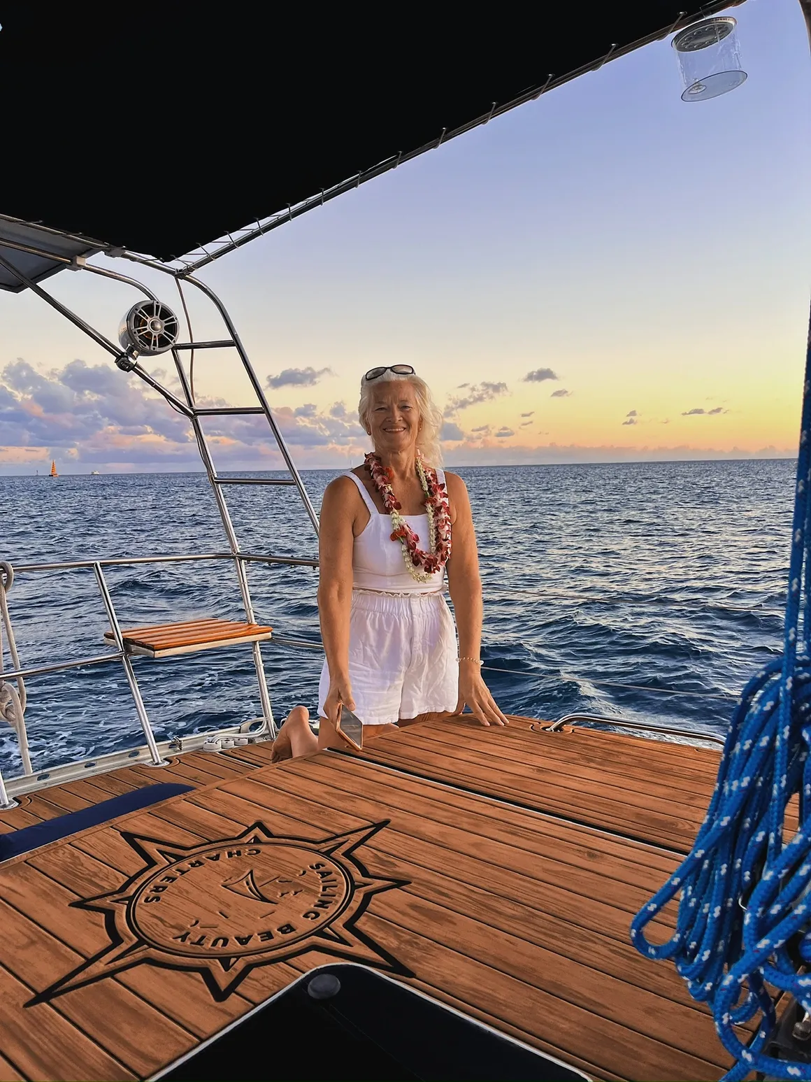 Guest wearing a celebratory lei at the stern of Sailing Beauty.