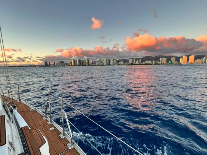 View from the side deck of Sailing Beauty toward the Honolulu skyline at sunset.